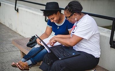 A parent with a student looking at a laptop